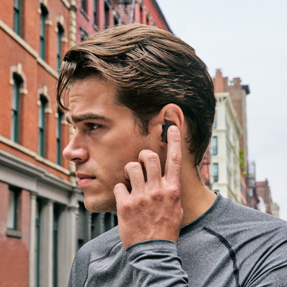 Model utilizing touch controls on the Status Between 3ANC earbuds