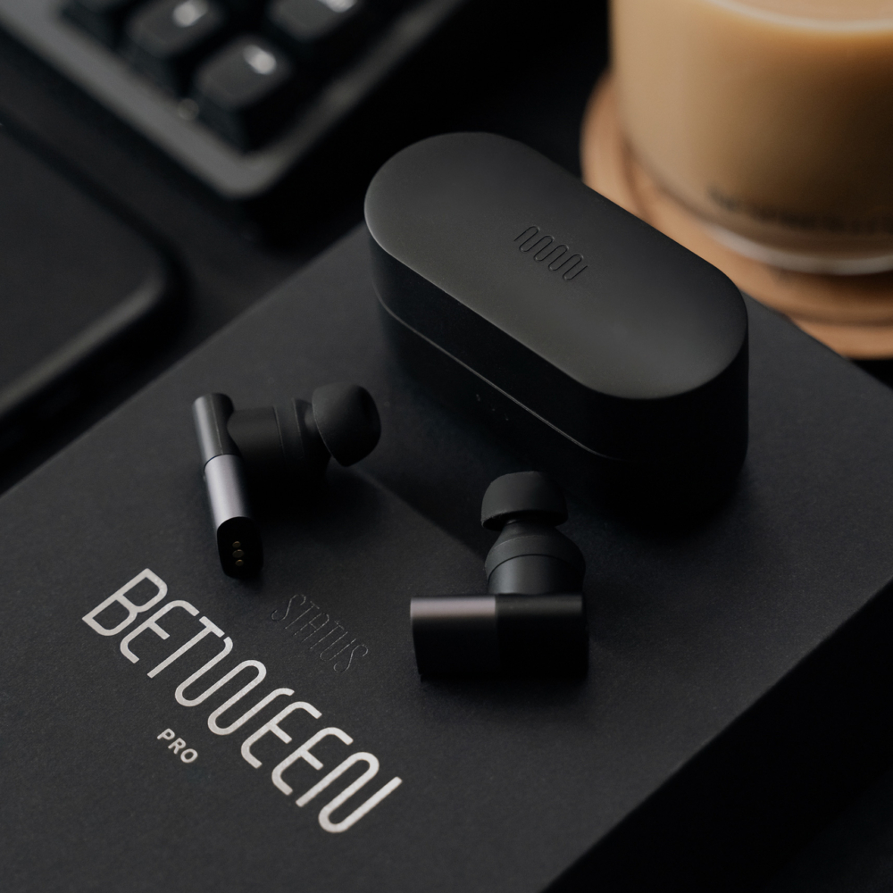 Status Between Pro Earbuds laid on top of it's packaging box