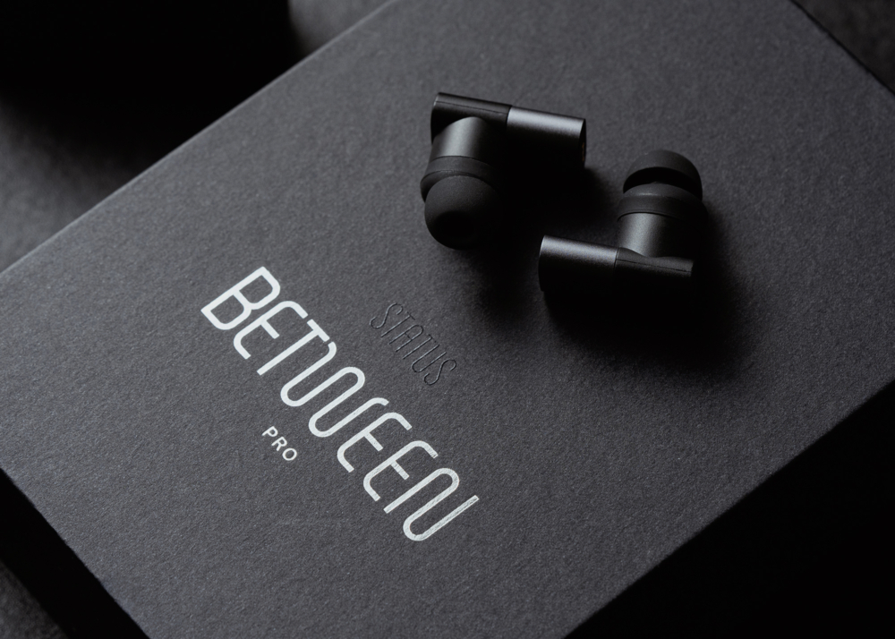 Cropped view of Status Between Pro packaging and earbuds