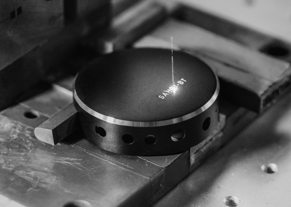 Status headphone case being laser etched with typography