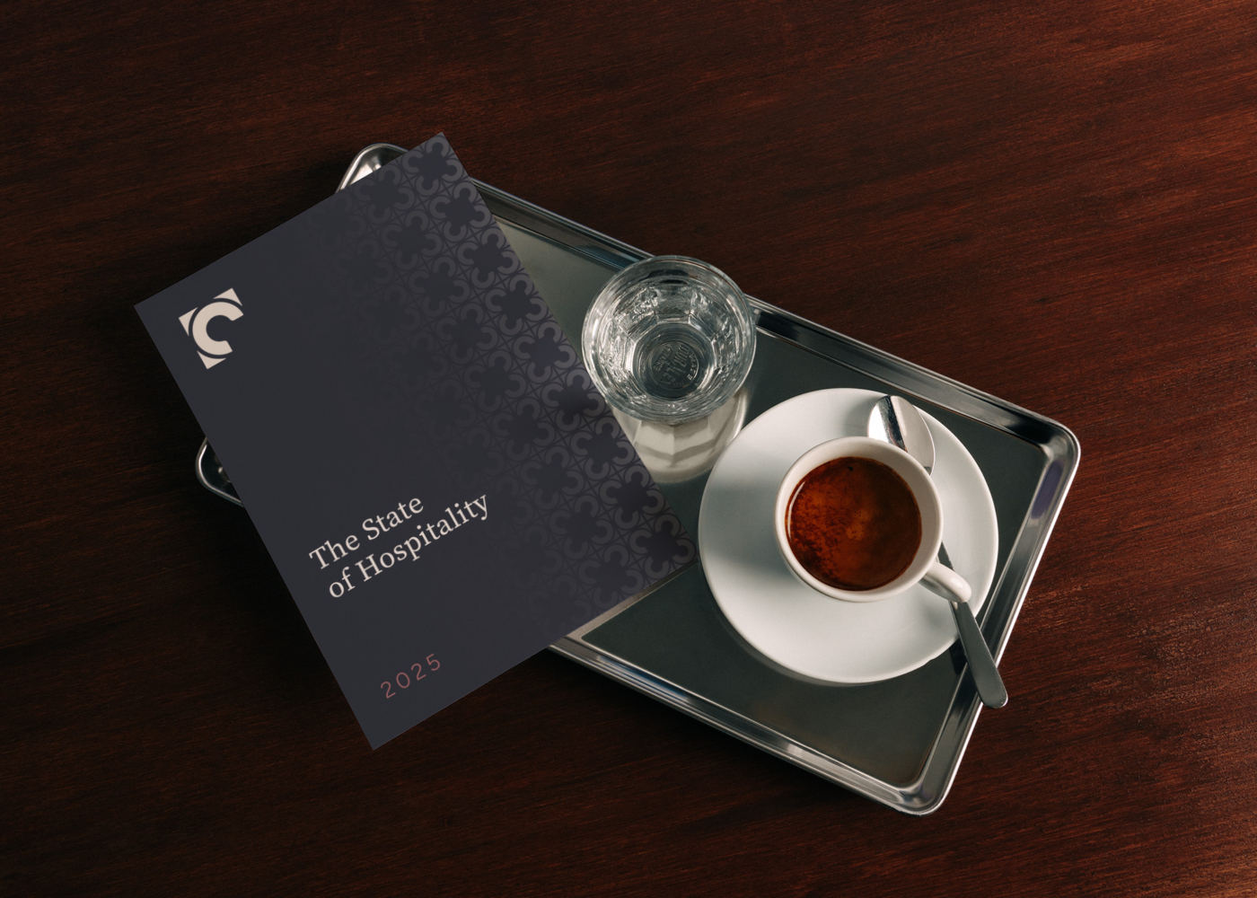 A branded Corner Booth Hospitality book on an espresso tray