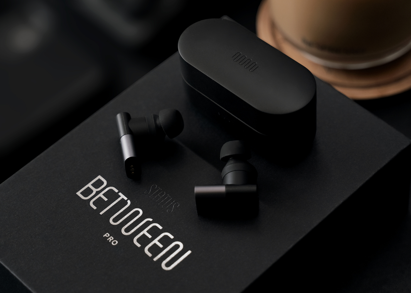 Status Between Pro Earbuds laid on top of it's packaging box