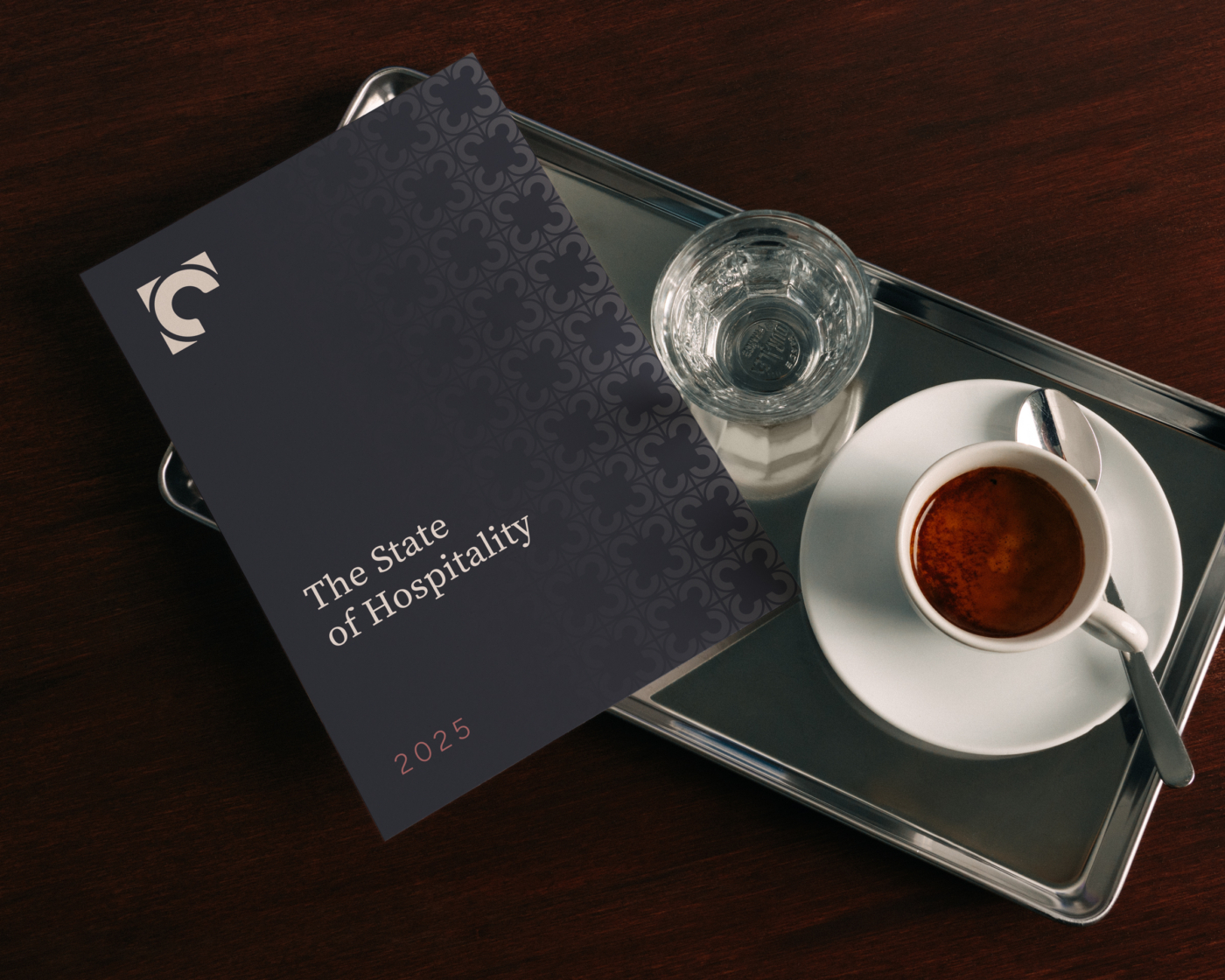 A branded Corner Booth Hospitality book on an espresso tray